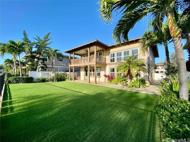 back of house featuring a yard and a balcony