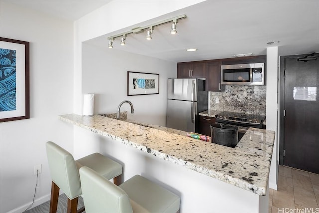 1777 Ala Moana Blvd Unit 2206, Honolulu, HI 96815 - kitchen with a kitchen bar, kitchen peninsula, stainless steel appliances, light stone countertops, and decorative backsplash