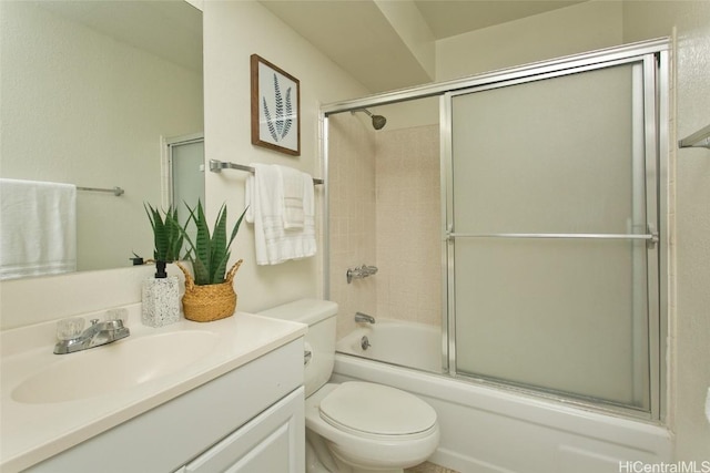 bathroom with bath / shower combo with glass door, vanity, and toilet