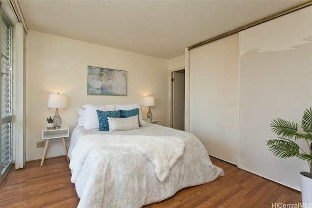 bedroom featuring a closet, a textured ceiling, and wood finished floors