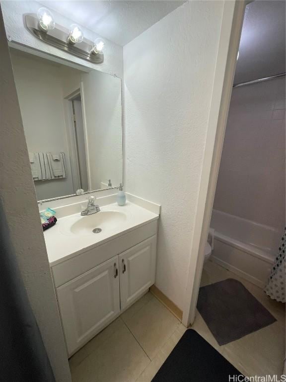 full bathroom featuring shower / tub combo with curtain, a textured wall, toilet, vanity, and tile patterned flooring