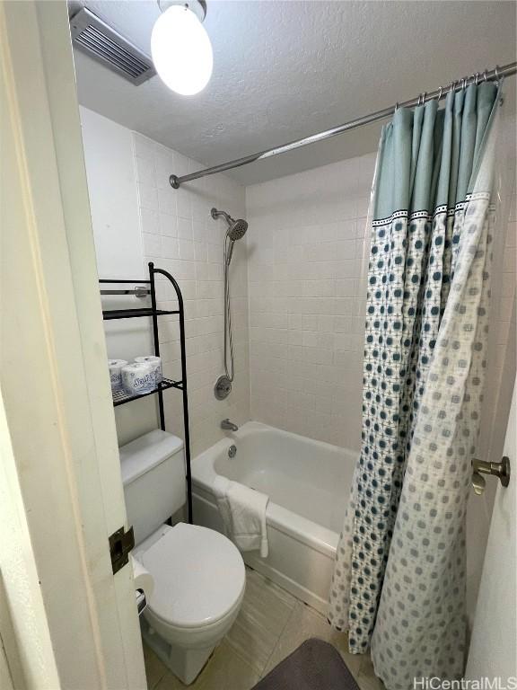 bathroom with toilet, a textured ceiling, visible vents, and shower / bathtub combination with curtain