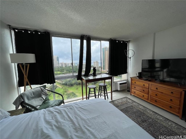 bedroom featuring concrete floors, floor to ceiling windows, and a textured ceiling