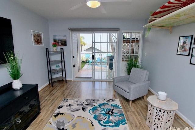 living area with ceiling fan and light hardwood / wood-style flooring