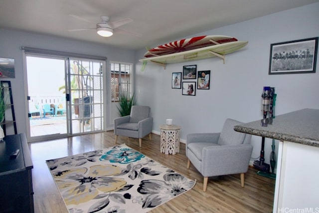 living area with hardwood / wood-style flooring and ceiling fan