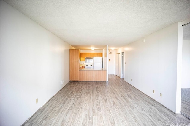 unfurnished living room with a textured ceiling and light wood-type flooring