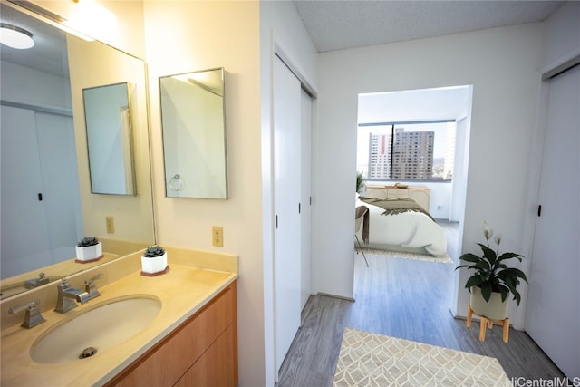 bathroom featuring vanity, hardwood / wood-style flooring, and a textured ceiling