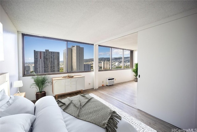 living room featuring a wealth of natural light, hardwood / wood-style floors, and a textured ceiling