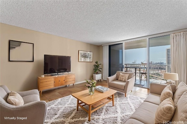 tiled living room featuring a textured ceiling and a wall of windows