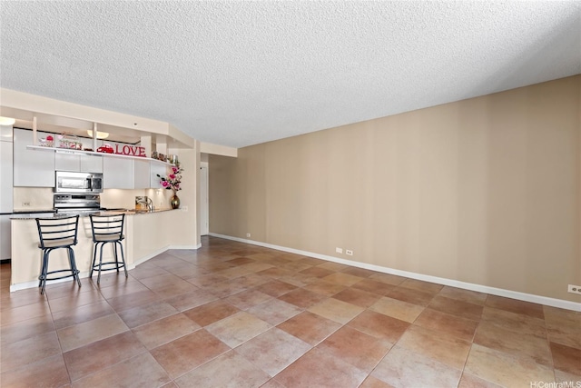 1212 Nuuanu Ave Unit 1412, Honolulu, HI 96817 - unfurnished living room featuring light tile patterned floors, a textured ceiling, and baseboards