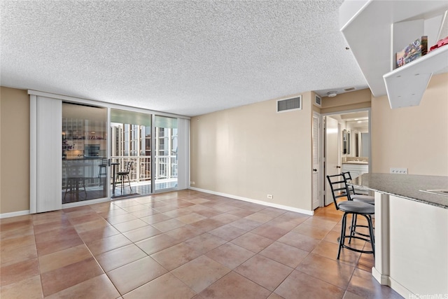 1212 Nuuanu Ave Unit 1412, Honolulu, HI 96817 - interior space featuring light tile patterned floors, a wall of windows, baseboards, visible vents, and a textured ceiling