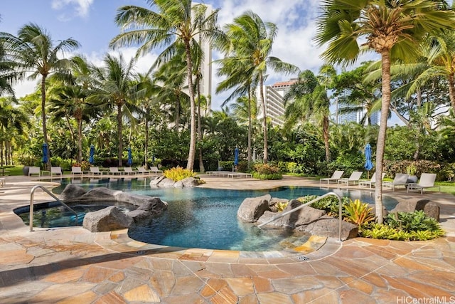 view of swimming pool featuring a hot tub and a patio