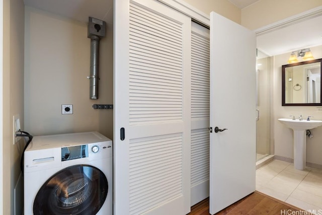 washroom with tile patterned floors, washer / clothes dryer, and sink