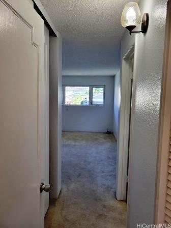 hallway featuring carpet floors and a textured ceiling