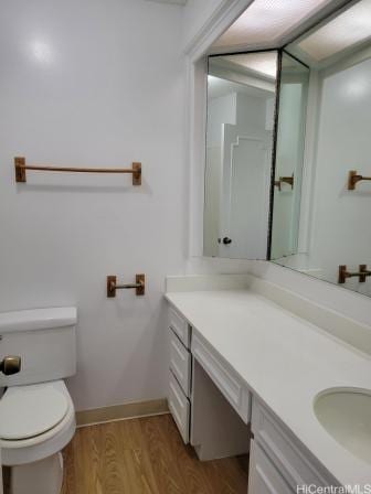 bathroom featuring hardwood / wood-style flooring, vanity, and toilet