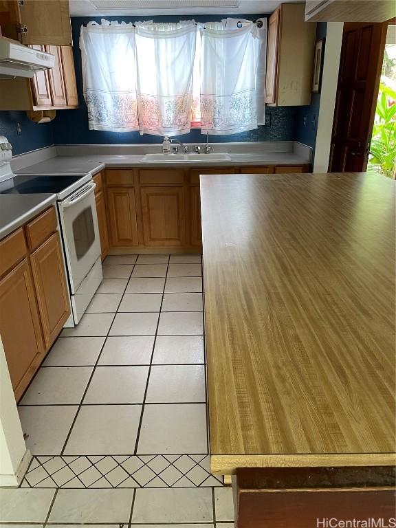 kitchen featuring sink, light tile patterned floors, and electric range