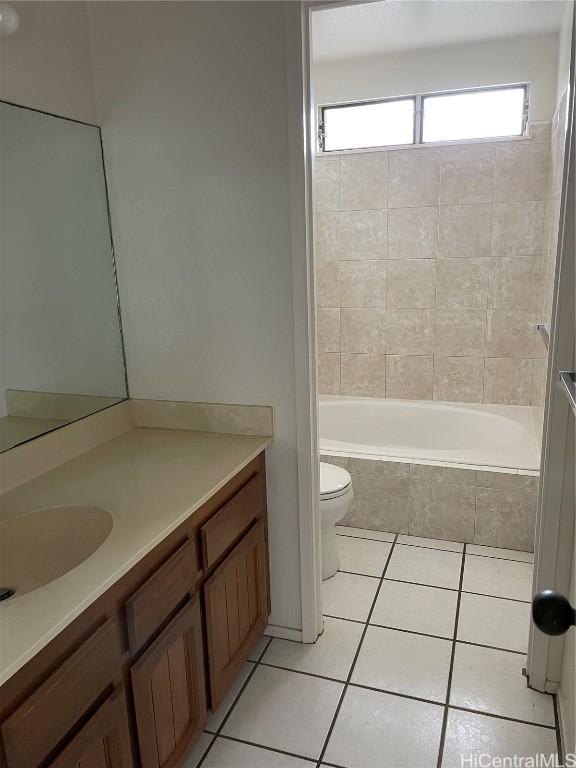 full bathroom featuring vanity, tiled shower / bath combo, tile patterned floors, and toilet