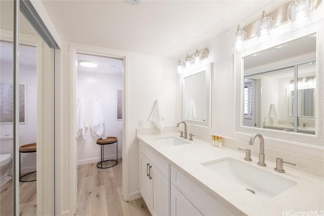 bathroom featuring vanity, wood-type flooring, and toilet