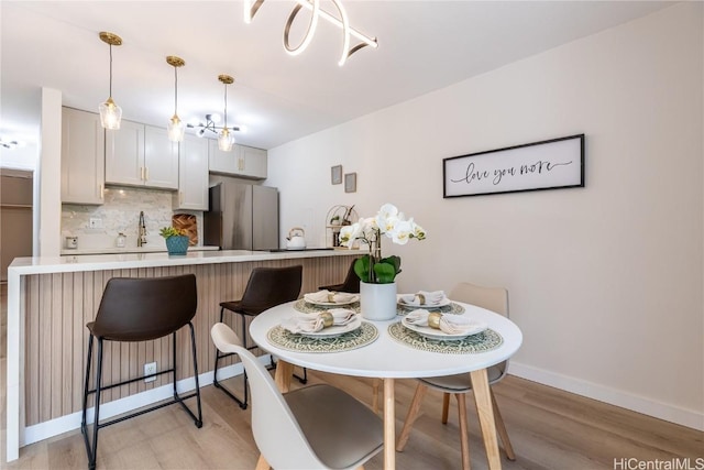 dining space with sink and light hardwood / wood-style flooring