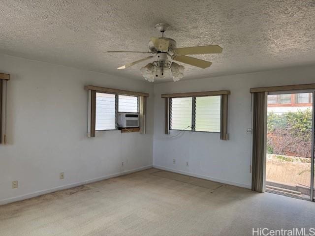 spare room with baseboards, plenty of natural light, cooling unit, and light colored carpet