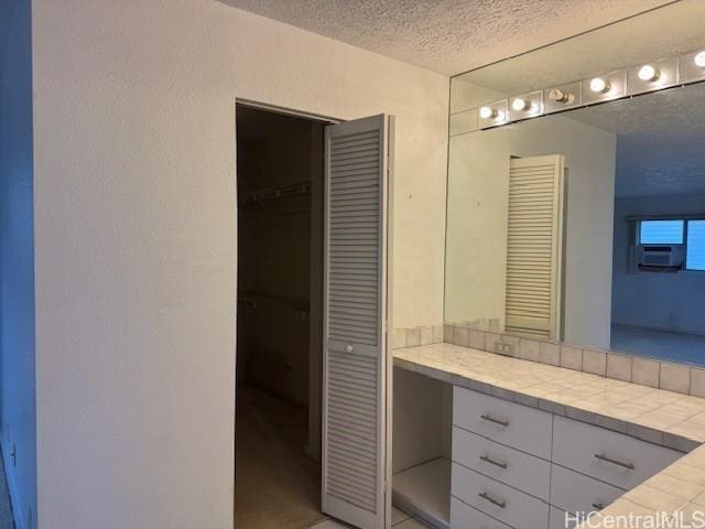 bathroom with a textured wall and a textured ceiling