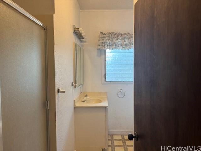 bathroom featuring a shower with door, vanity, and tile patterned floors