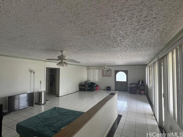 unfurnished living room with a ceiling fan, a textured ceiling, and light tile patterned floors