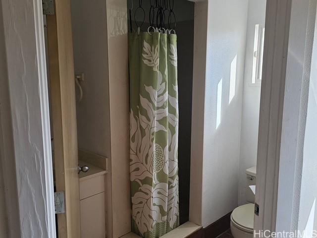 full bath with a shower with shower curtain and toilet