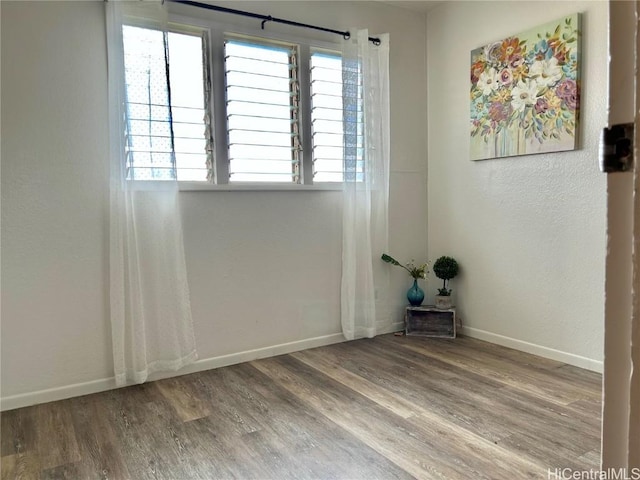 unfurnished room with wood-type flooring