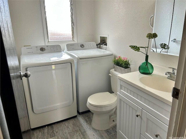 98-1385 Hinu Pl Unit 77, Pearl City, HI 96782 - bathroom featuring independent washer and dryer, toilet, vanity, wood finished floors, and a textured wall
