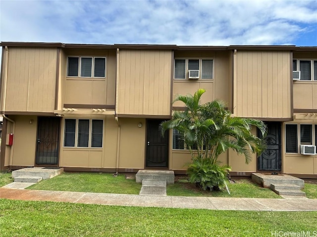 view of property featuring cooling unit and a front yard