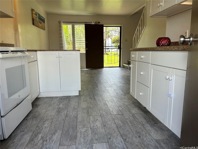 98-1385 Hinu Pl Unit 77, Pearl City, HI 96782 - kitchen featuring white range with electric stovetop, dark wood-style floors, white cabinets, and dark countertops