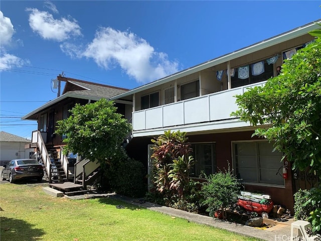 view of front of property with a front yard and a balcony