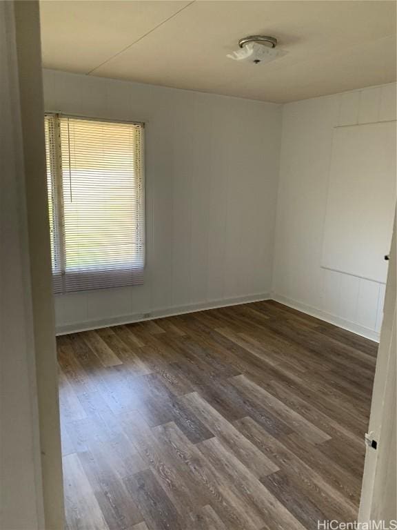 empty room with dark hardwood / wood-style flooring