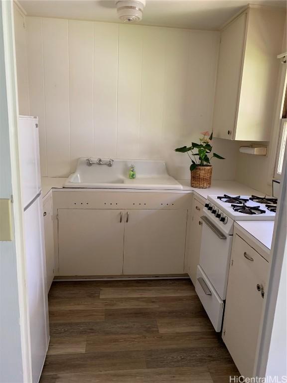 kitchen featuring white cabinetry, white appliances, sink, and dark wood-type flooring