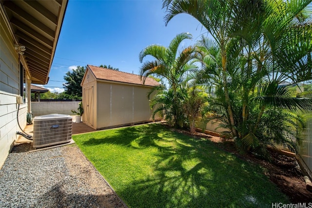 view of yard featuring a storage shed, a fenced backyard, an outdoor structure, and cooling unit