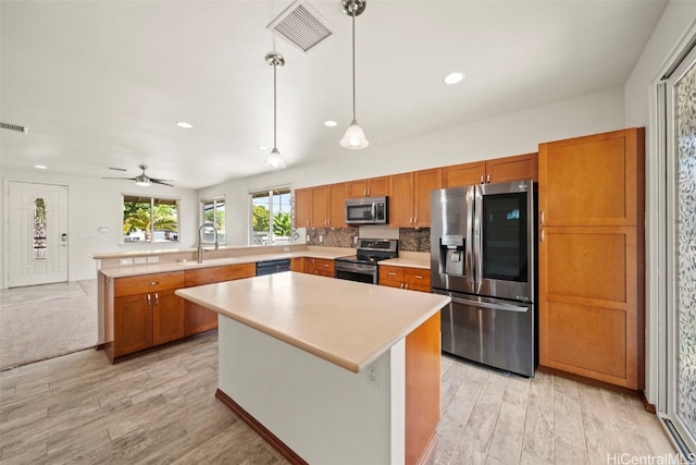 kitchen featuring appliances with stainless steel finishes, light countertops, visible vents, and a peninsula