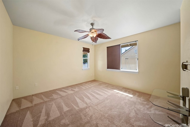 carpeted empty room featuring a ceiling fan