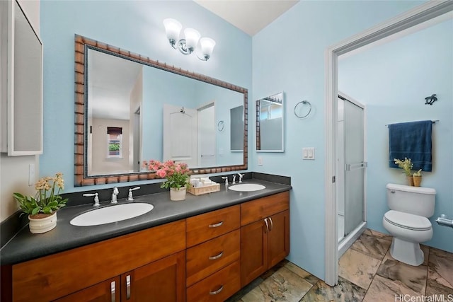 bathroom with double vanity, a stall shower, a sink, and toilet