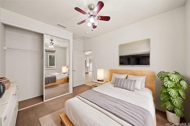 carpeted bedroom with a ceiling fan, a closet, and visible vents