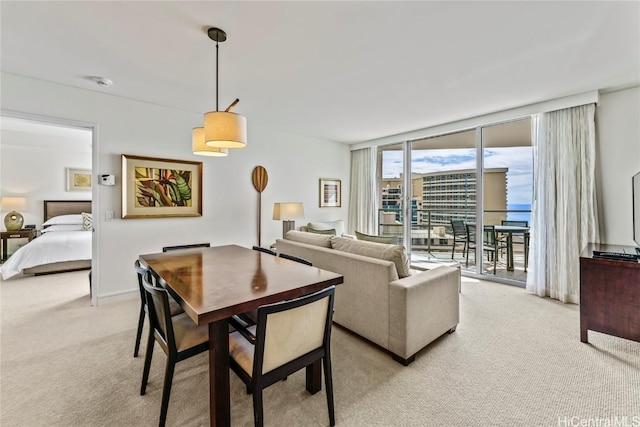 dining area with light carpet and a wall of windows