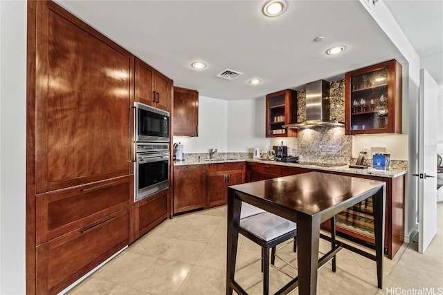 kitchen with sink, light stone counters, black appliances, light tile patterned flooring, and wall chimney exhaust hood