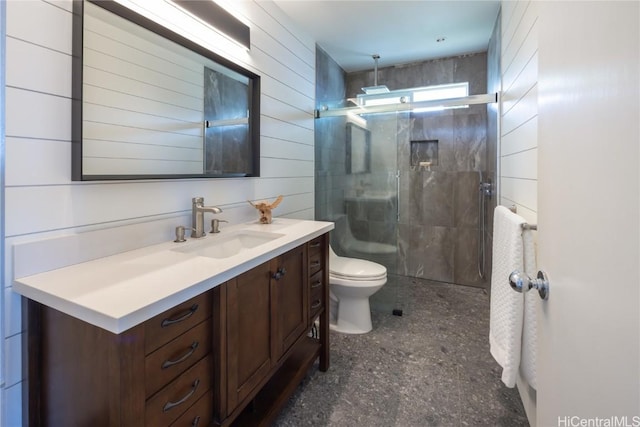 full bathroom featuring wood walls, toilet, a shower stall, and vanity