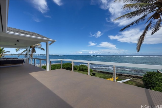 view of patio featuring a water view and a beach view