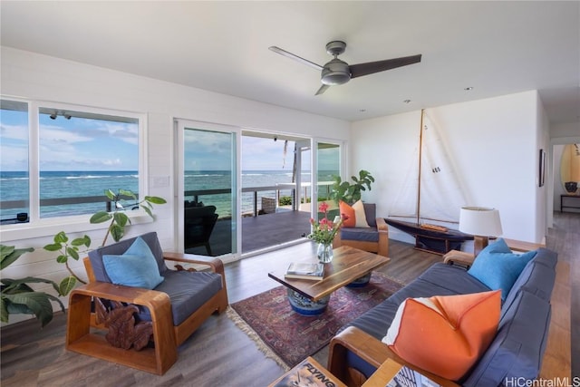 living room featuring a water view, wood finished floors, and a ceiling fan