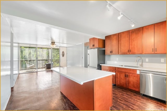 kitchen featuring light countertops, appliances with stainless steel finishes, a sink, and a center island