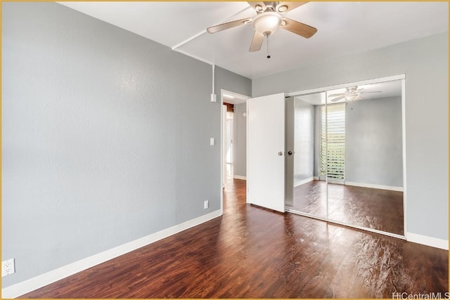 unfurnished bedroom with dark hardwood / wood-style flooring, a closet, and ceiling fan