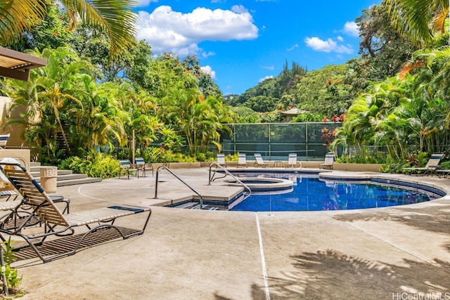 community pool featuring a patio area, fence, and a community hot tub