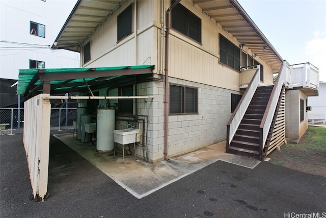 view of side of home with water heater and sink