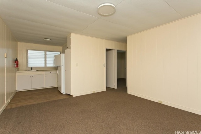 unfurnished room with sink and dark colored carpet